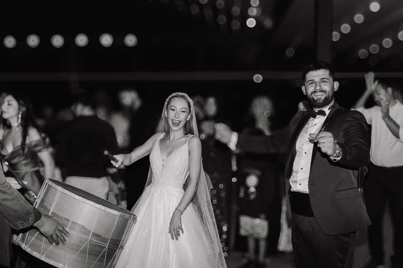 Multicultural wedding couple entering reception with family traditions and live musicians