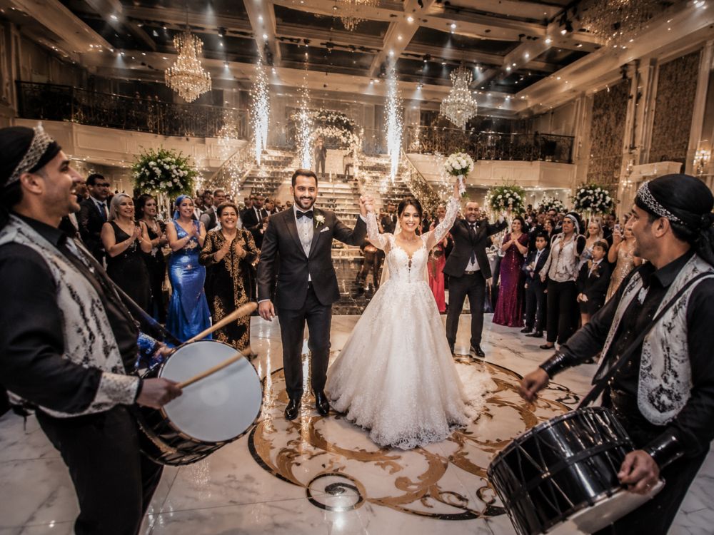 Guests cheering during a multicultural wedding entrance with cultural music and traditional performers in Melbourne