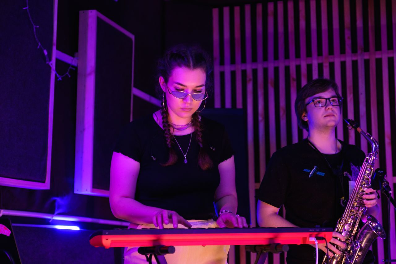 DJ and live saxophone duo creating an energetic hybrid entertainment experience at a modern wedding reception.