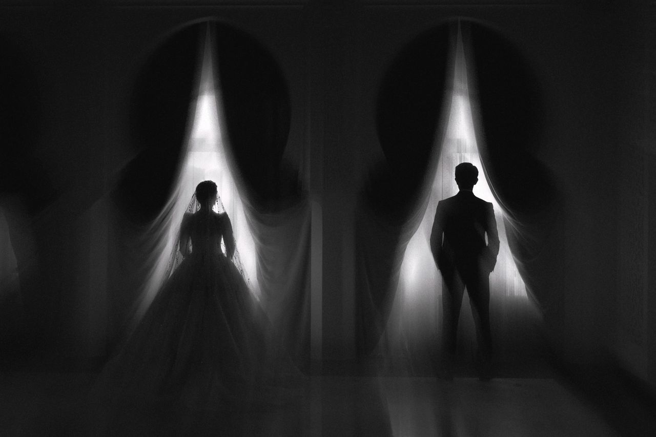 Newlywed couple revealed behind curtains during a dramatic wedding reception entrance in an elegant ballroom