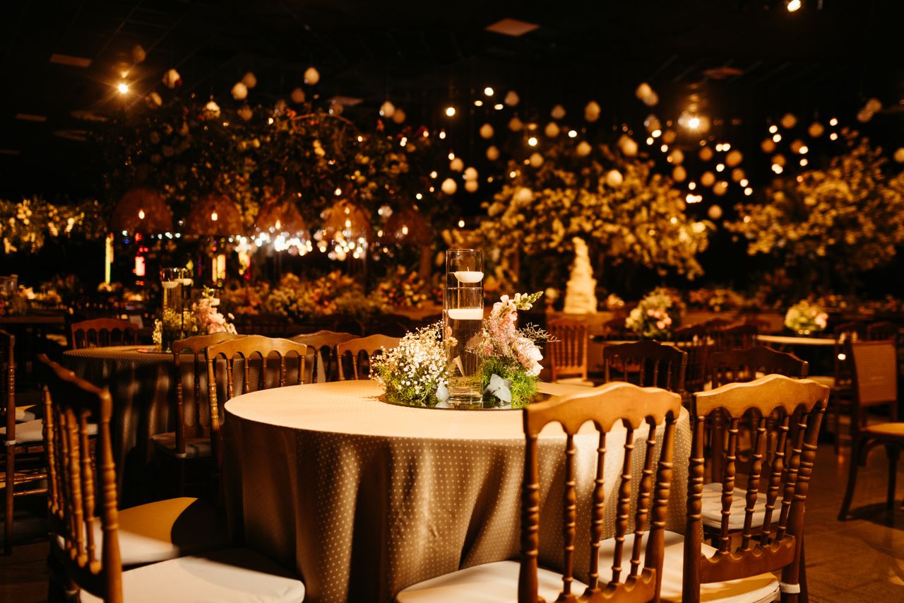 Outdoor marquee wedding reception decorated with fairy lights, chandeliers and ambient evening lighting