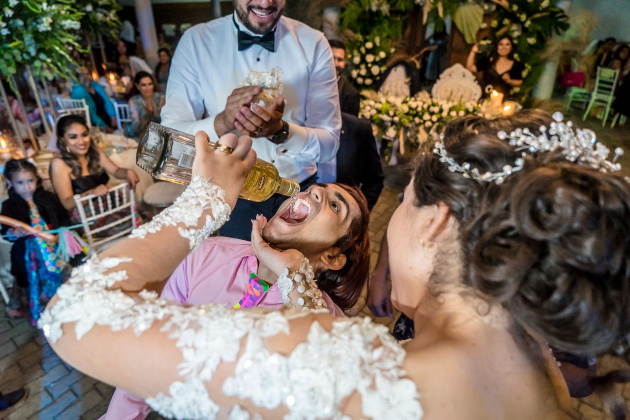 Guests playing personalised lawn games during a wedding cocktail hour with laughter, drinks, and outdoor entertainment.