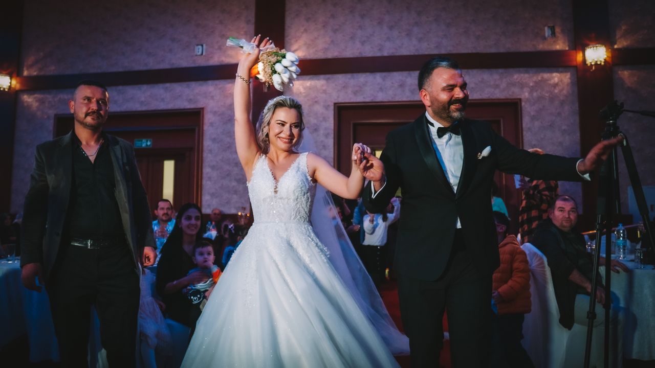 Newlywed couple entering a ballroom reception as guests celebrate during a dramatic wedding entrance