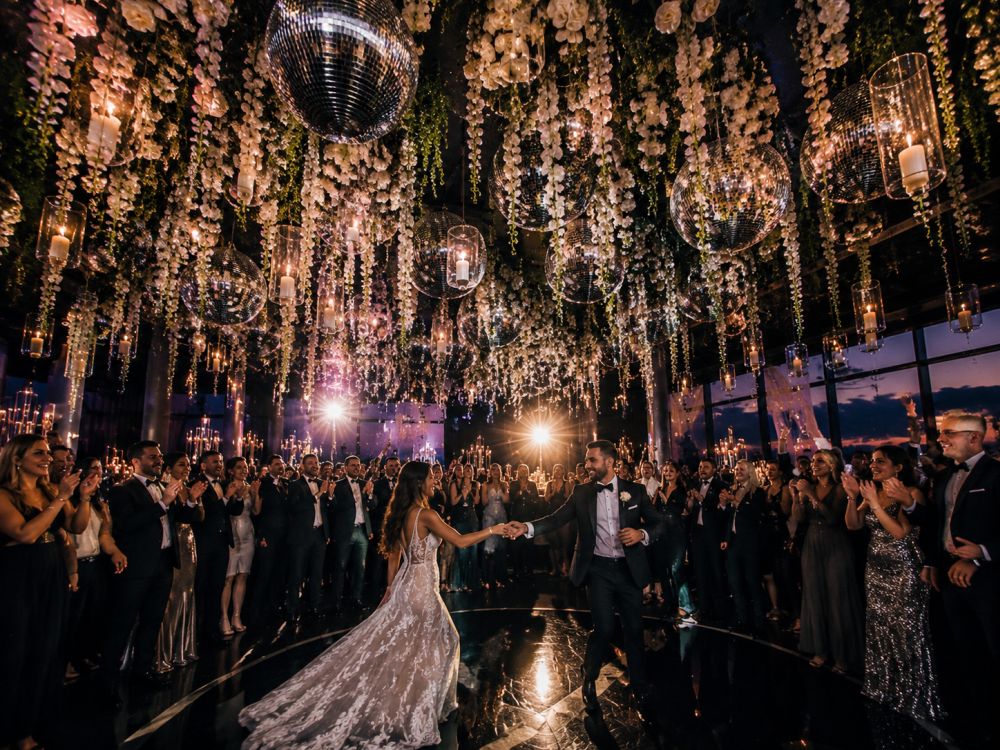 Contemporary wedding reception featuring suspended flowers, disco balls, and modern floral styling