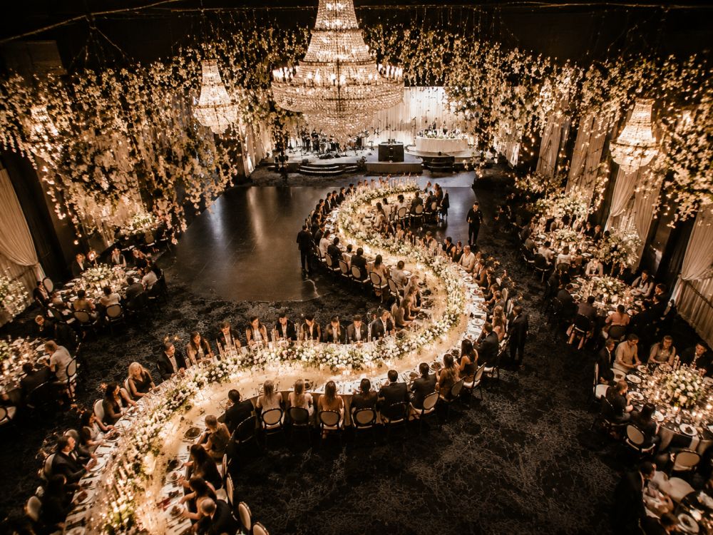 Aerial editorial view of an S-shaped curved wedding table arrangement creating a dramatic ballroom reception design.