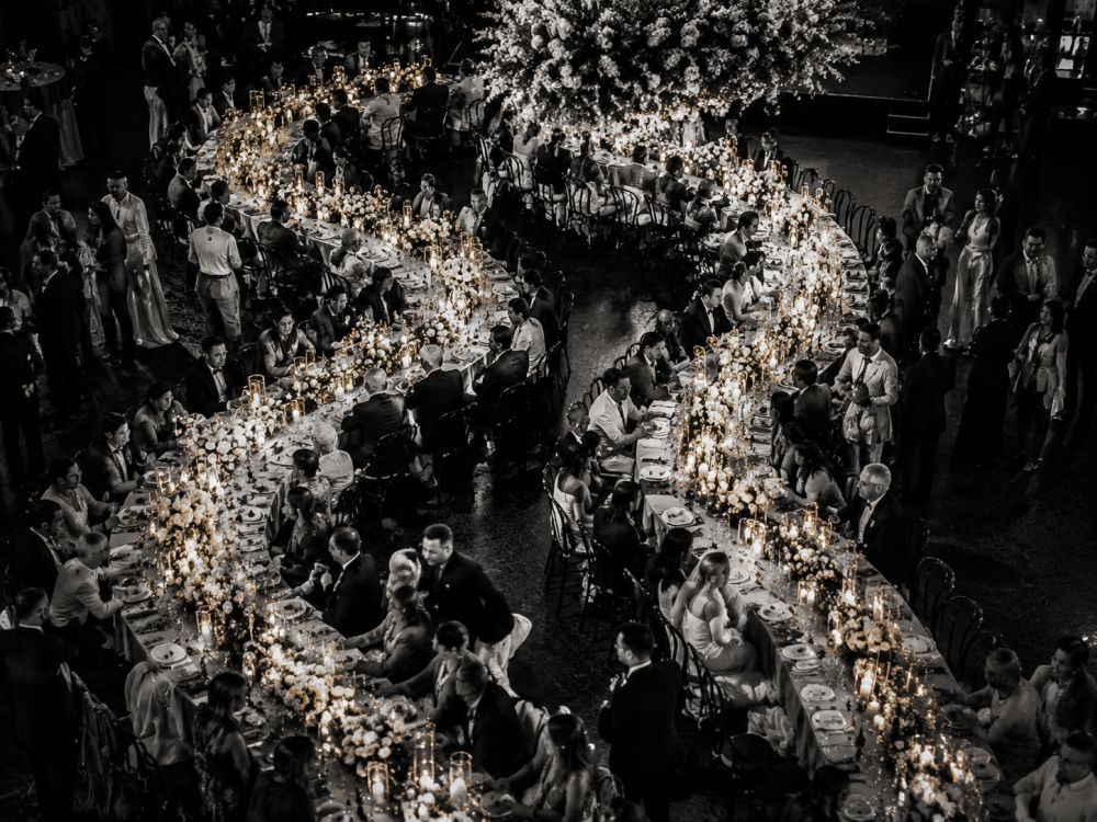 Diverse wedding guests celebrating together around a flowing curved reception table layout in Melbourne.