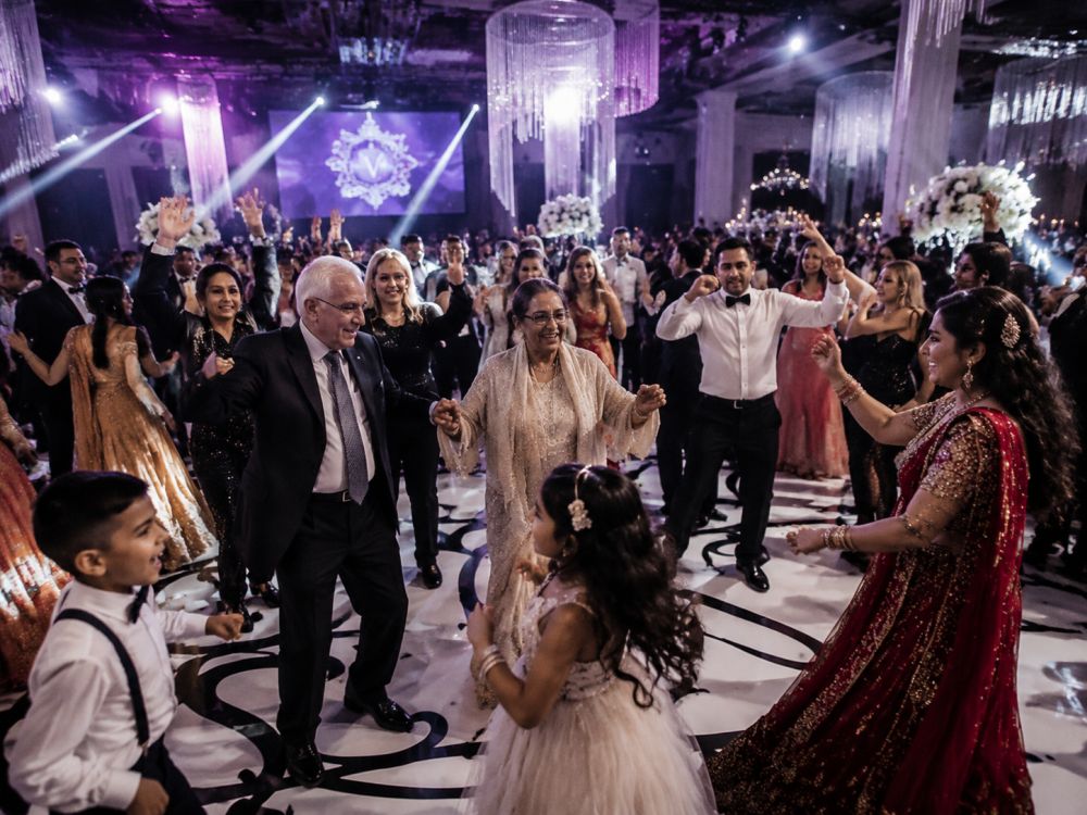 Multiple generations dancing together during a vibrant multicultural wedding reception in Melbourne