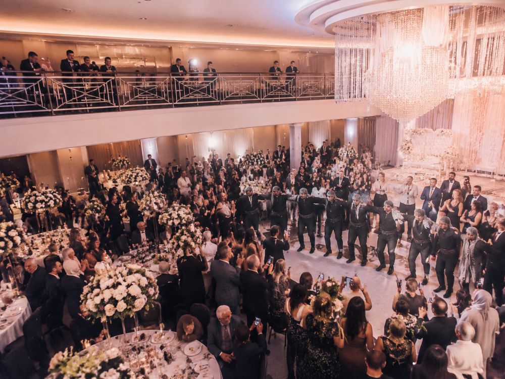 A Melbourne multicultural wedding reception featuring Lebanese Dabke dancers and diverse guests celebrating together in a ballroom