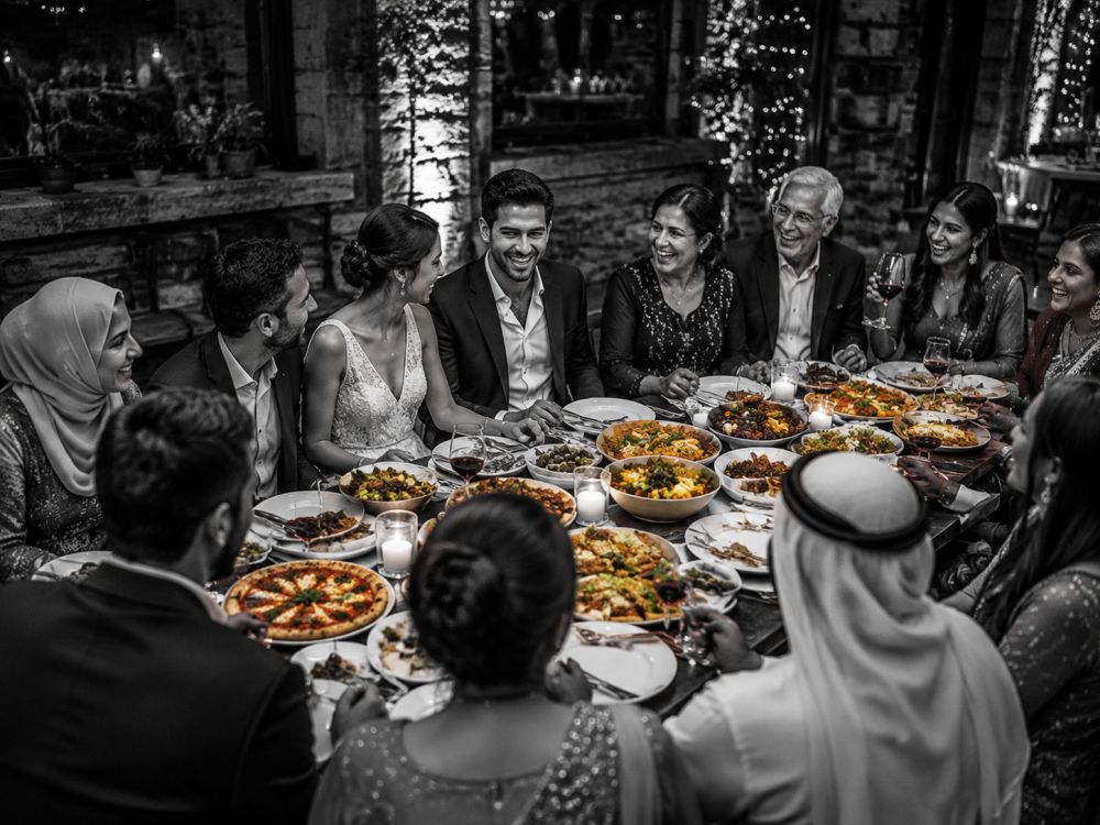 Diverse families celebrating together through cultural food traditions at a wedding welcome dinner