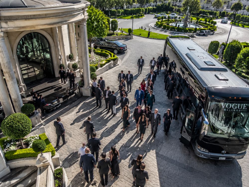 Wedding guests arriving together from a coach service at a reception venue with organised transport planning.