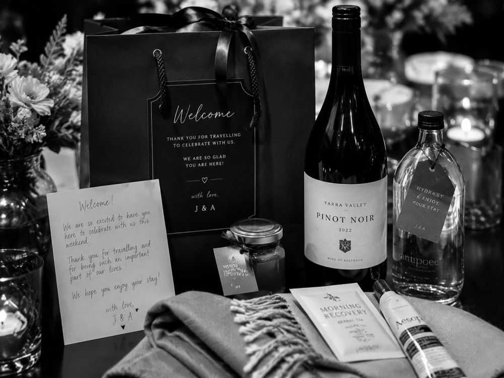 Wedding welcome gifts, handwritten notes, and local items arranged on a pre-wedding dinner table
