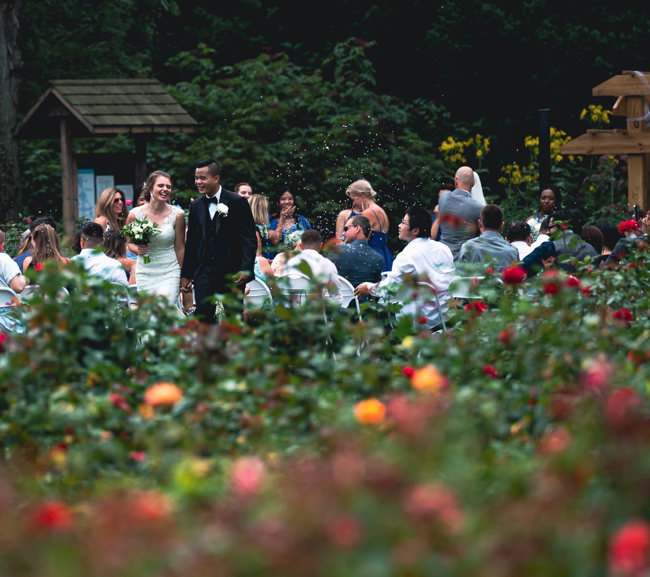 Outdoor Melbourne spring wedding ceremony showing flowers, guests and changing weather conditions.