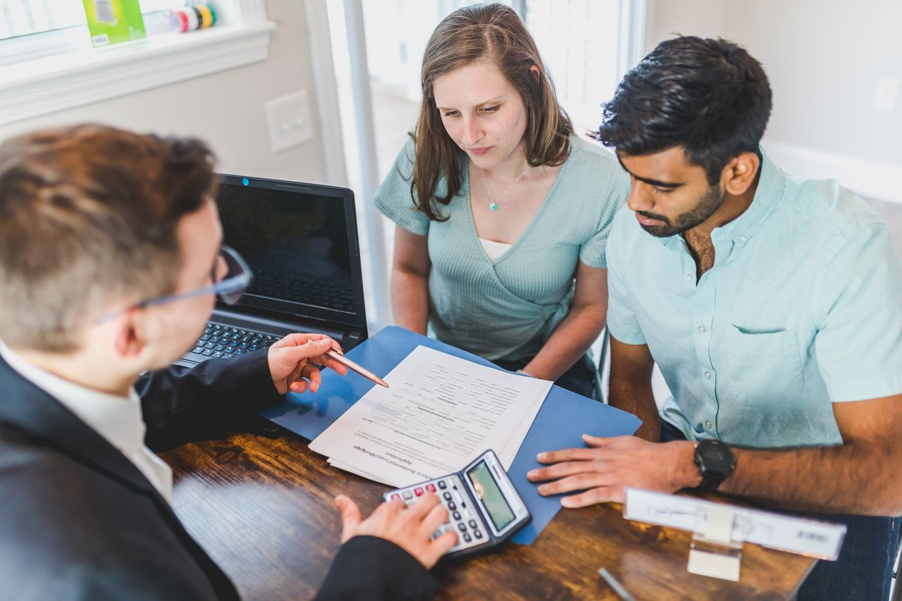 Couple reviewing wedding venue contracts and invoices while discovering additional charges affecting their budget.