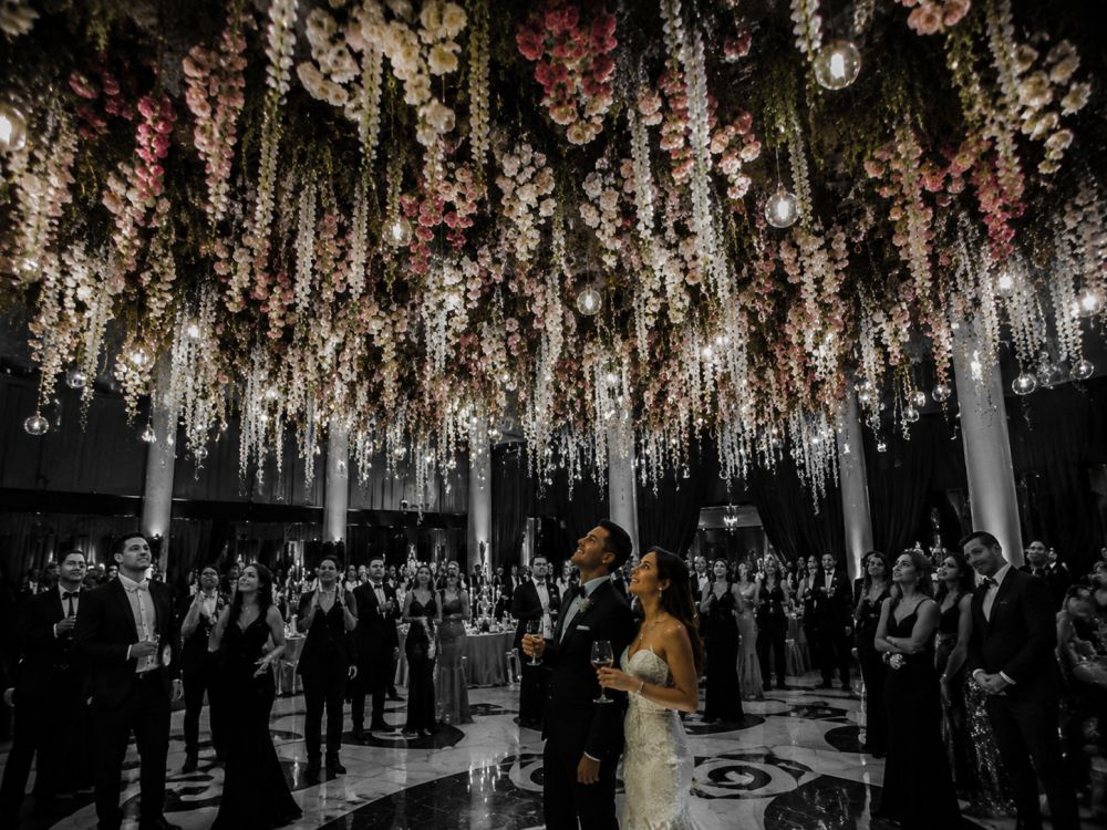 Large-scale upside-down floral garden installation transforming a luxury wedding venue ceiling