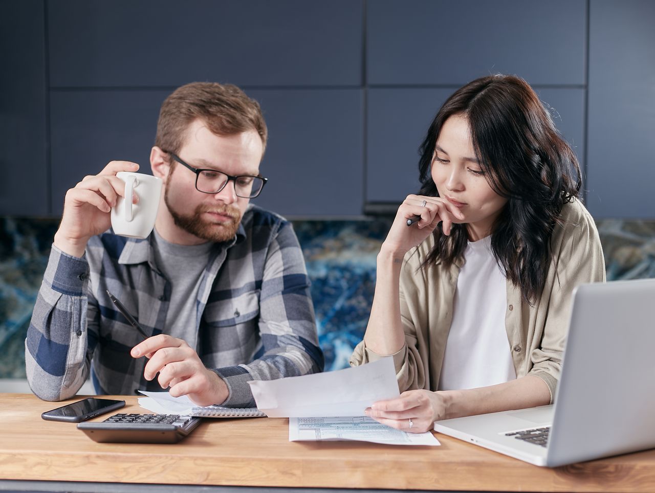 Couple reviewing wedding expenses and comparing venue costs during planning