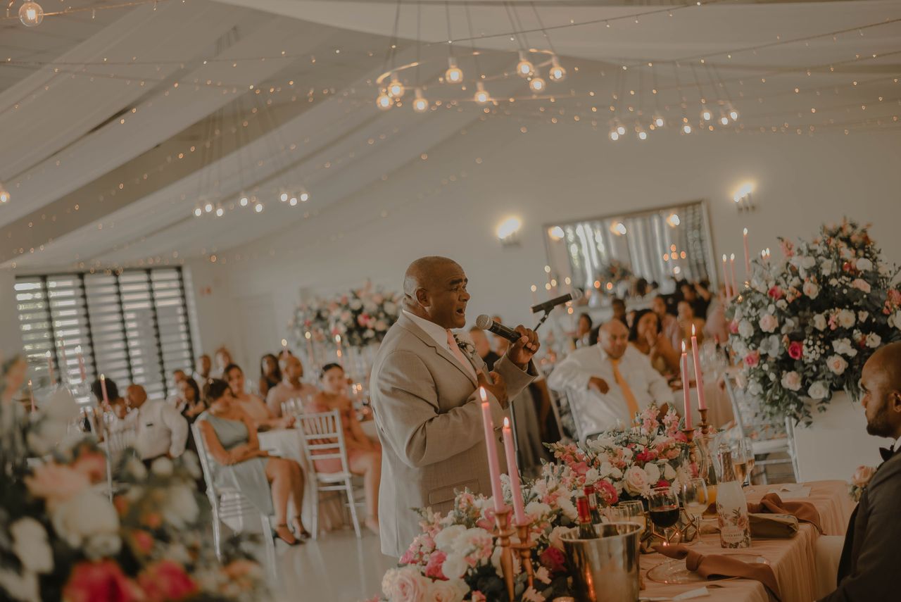 Wedding MC guiding guests through reception formalities with microphone during a carefully planned celebration