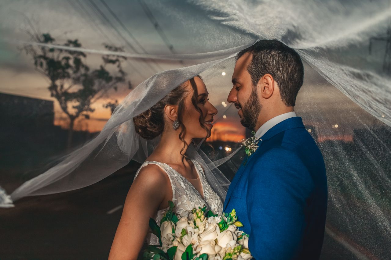 Photographer capturing newlywed sunset portraits while protecting important wedding reception timing