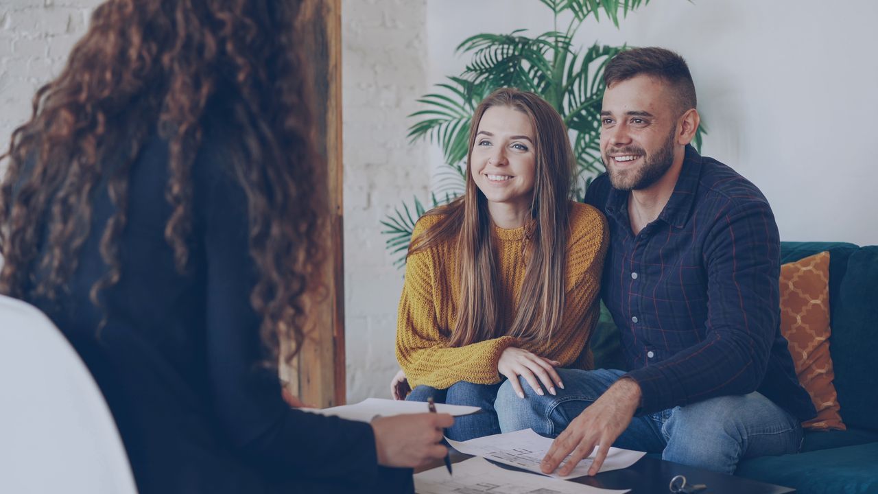 Couple reviewing wedding plans and venue options with organised planning materials