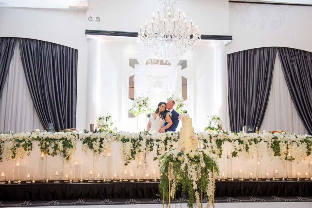 bride and groom at posing at table vogue ballroom