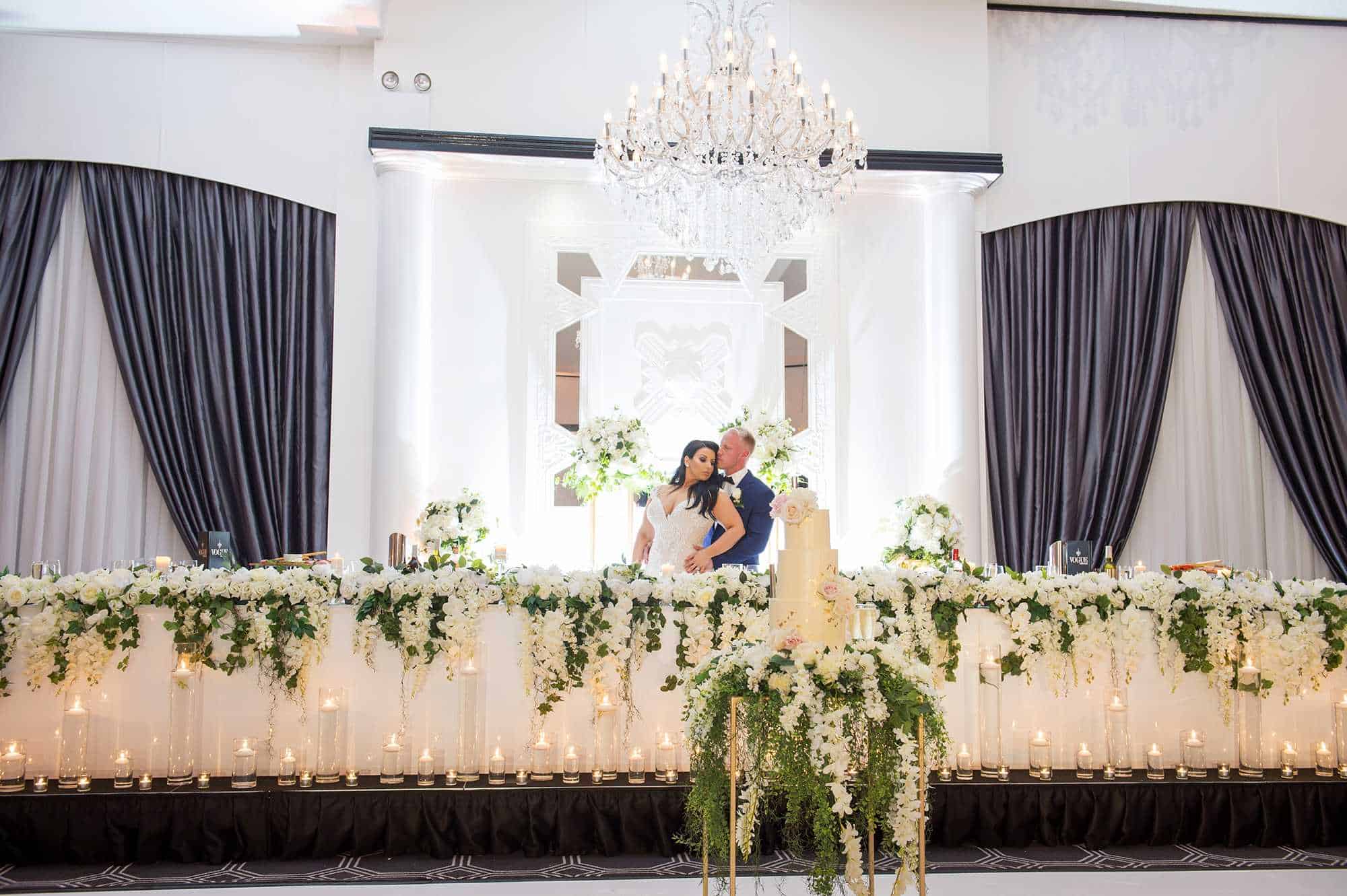 bride and groom at posing at table vogue ballroom